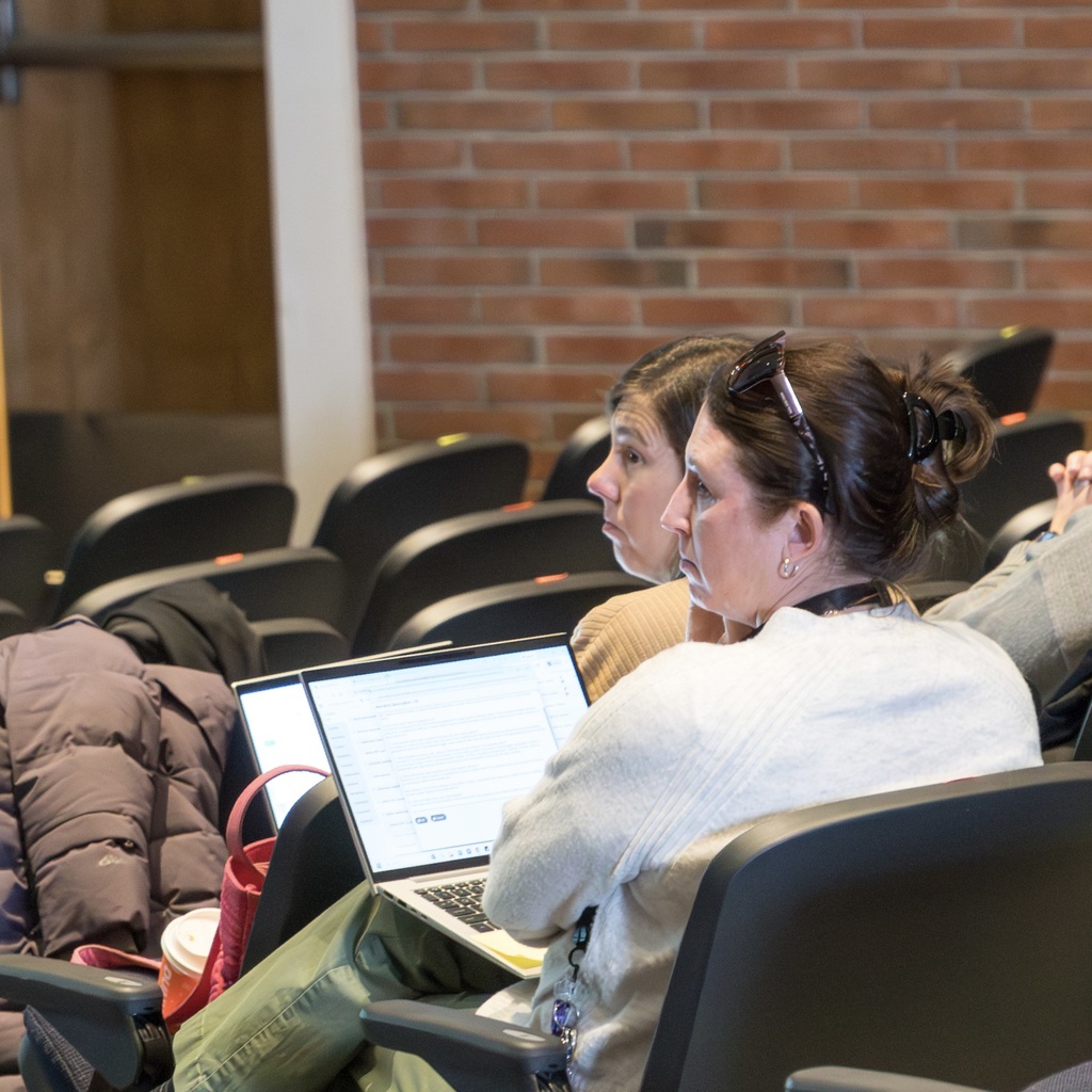 Two MPS staff members sit in the Whitcomb auditorium.