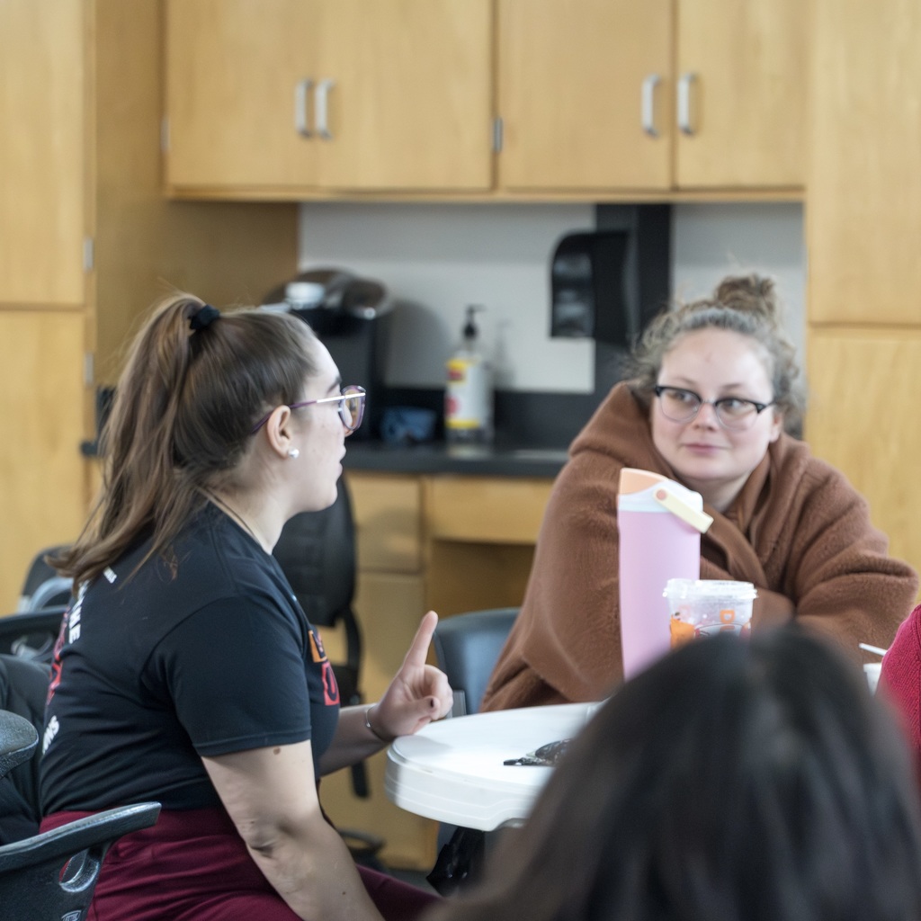 Two MPS staff members talk at a table in the Whitcomb Commons.