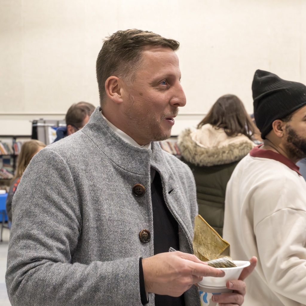 Mayor Christian stands in the Richer School cafeteria, enjoying a snack.