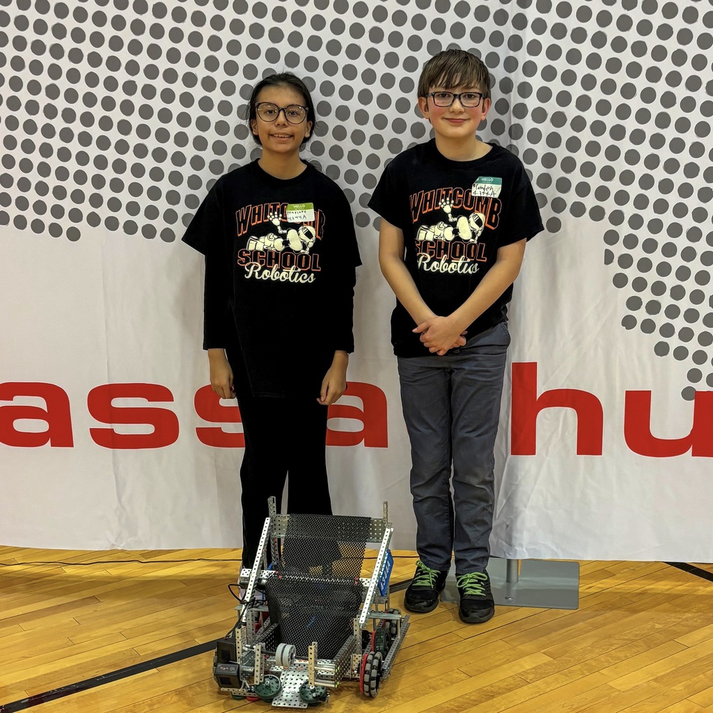 Two student members of the Whitcomb Schools VEX Robotics team pose with their robot.