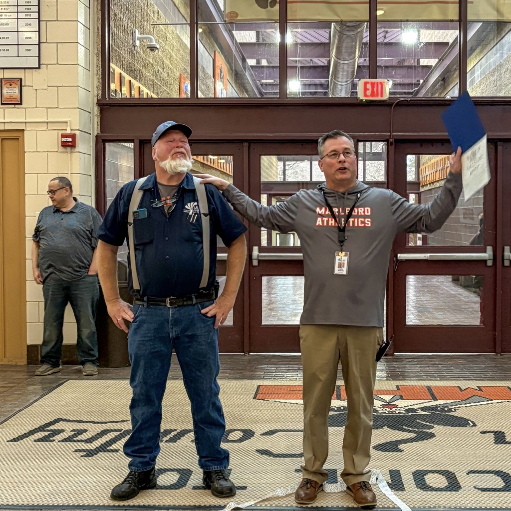 Jimmy O'Coin and Principal Sierpina stand in the lobby of Marlborough High School.