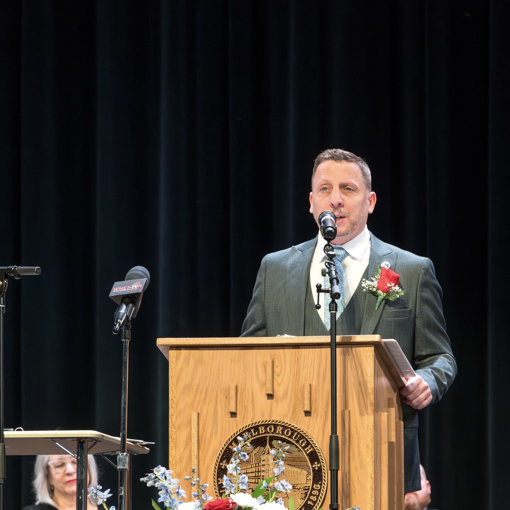 Mayor Christian stands behind a podium, giving a speech.