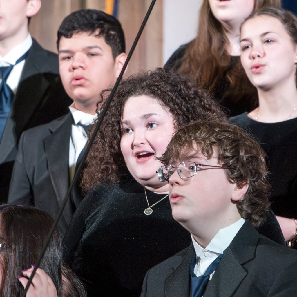 Voices ReChoired members stand and sing.