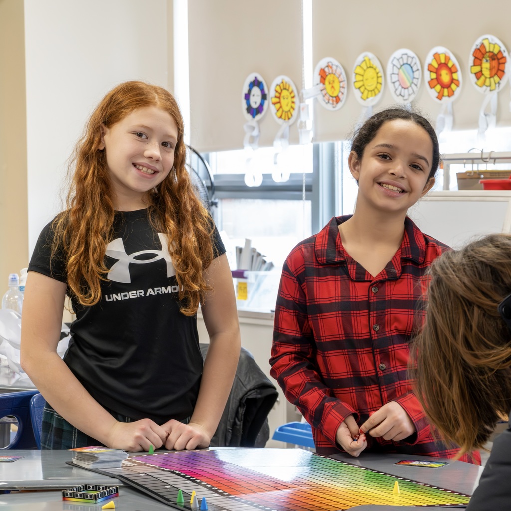 Two Jaworek school girls stand and smile at the camera.