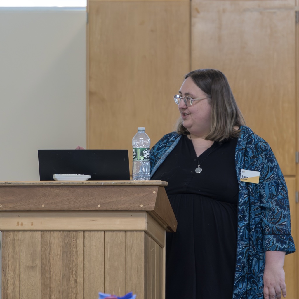 A guest speaker stands behind a podium.