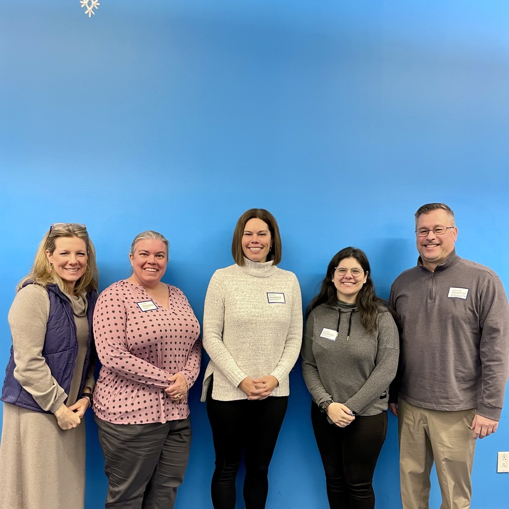 Marlborough High School Principal Stephen Sierpina and four staff members pose for a group photo standing in front of a blue wall.