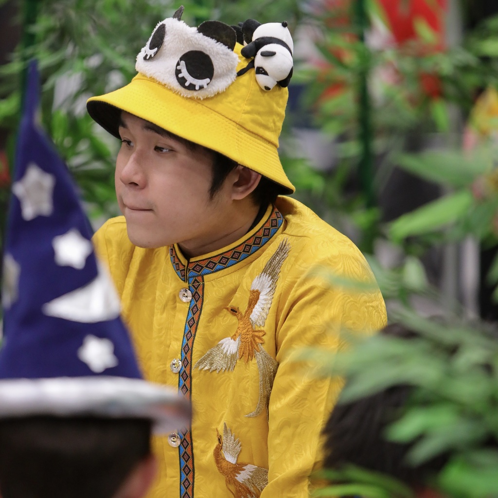 Person in a yellow shirt with a yellow hat with pandas on it.