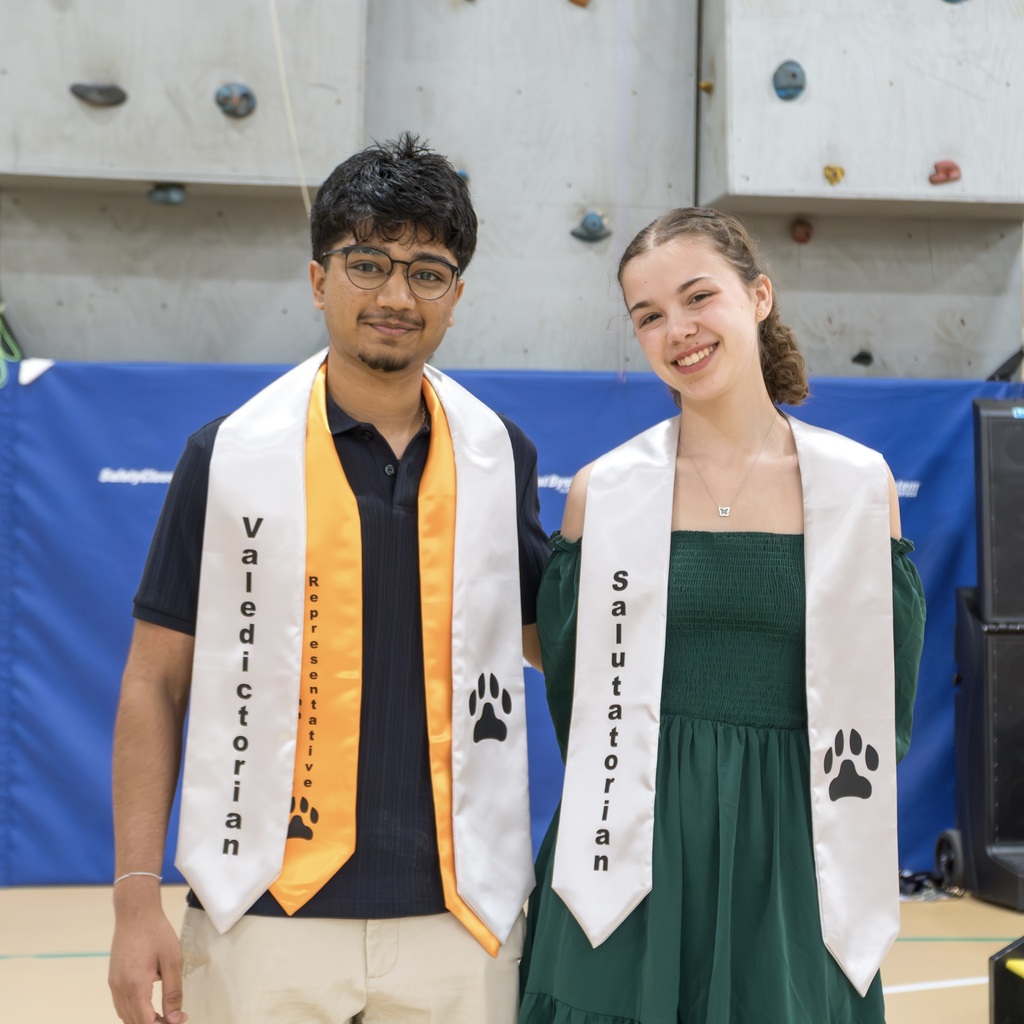 The Marlborough High School 2026 valedictorian and salutatorian in a gym pose for a photo wearing graduation stoles with paw prints.