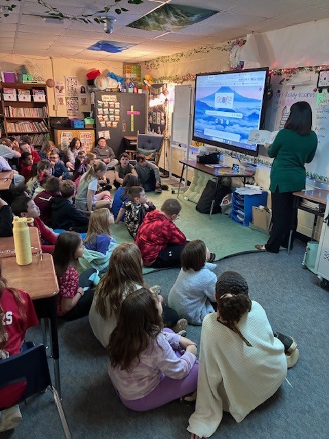 Miss Holly talks to 3-rd grade students