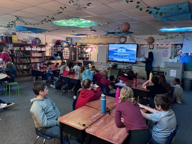 Miss Holly talks to 3-rd grade students