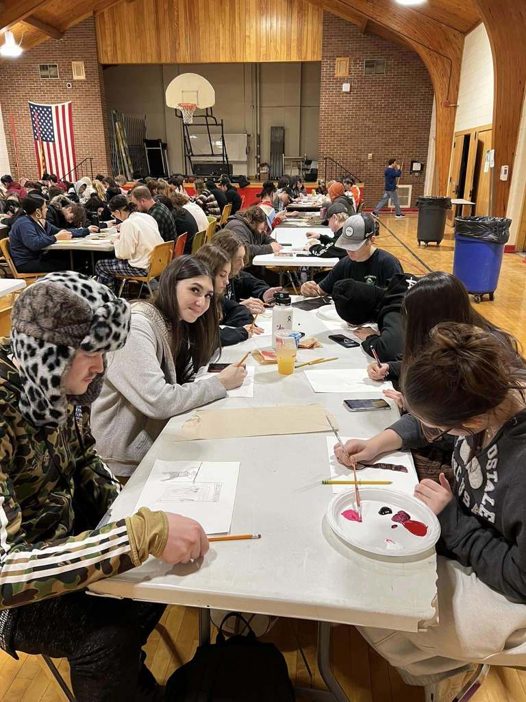 MAHS students painting art together in the gymnasium