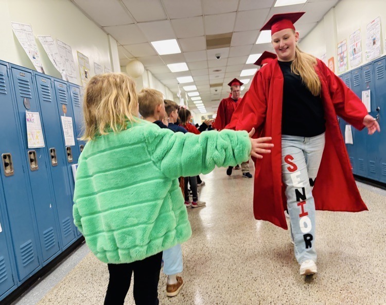 seniors high fiving students in the Graveraet halls