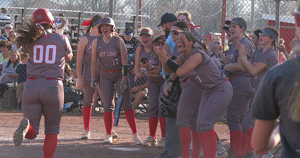 Marshall's McKenzie Davis (00) is greeted at home plate by her teammates after smashing a home run against Hut-Pal
