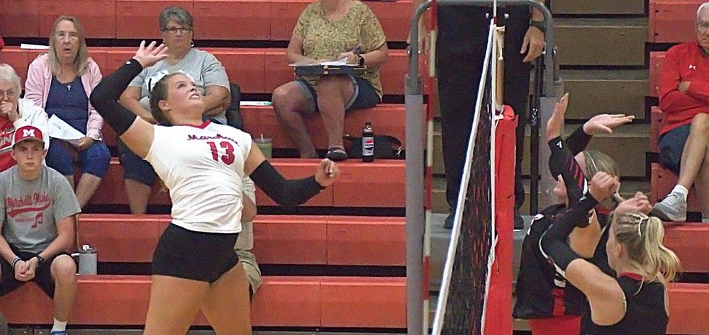 Marshall senior McKenzie Davis (13) pounds a strike against Chrisman during the Lions sweep