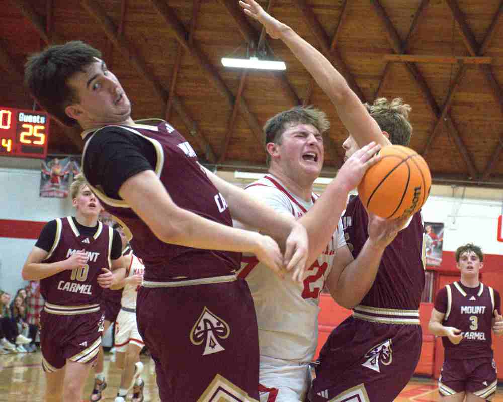 Garrett Pugh works between 2 Mt. Carmel Defenders