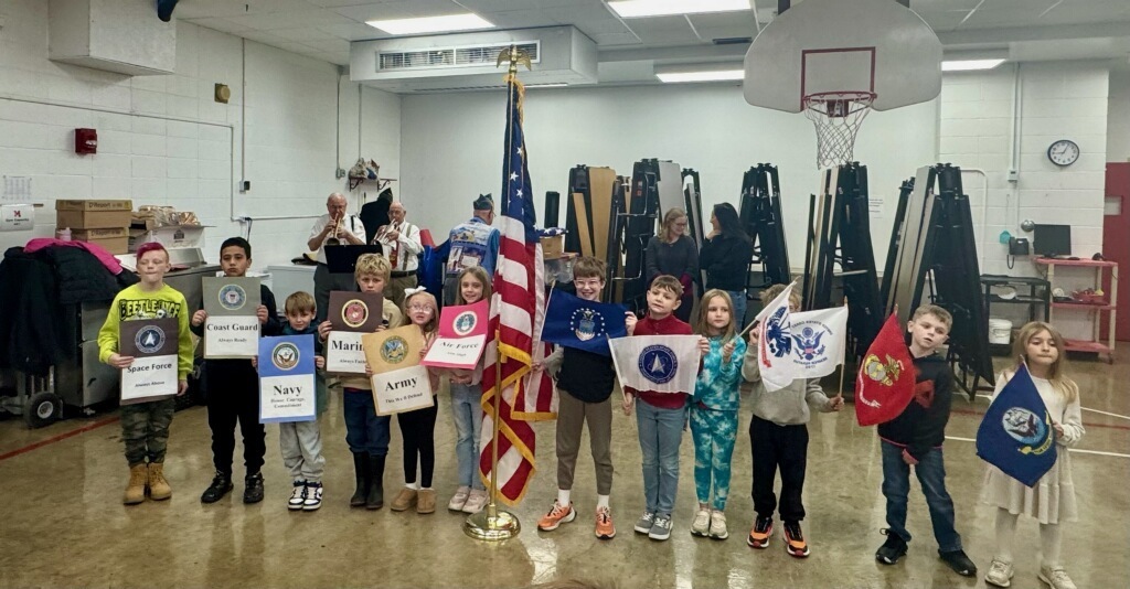 2nd grade students holding flags and signs for the different branches