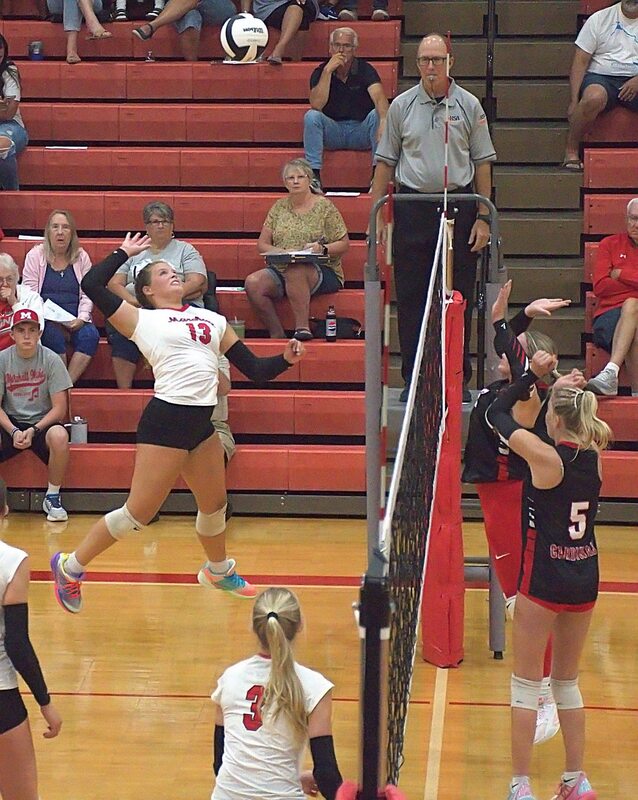 Marshall senior McKenzie Davis (13) pounds a strike against Chrisman during the Lions sweep