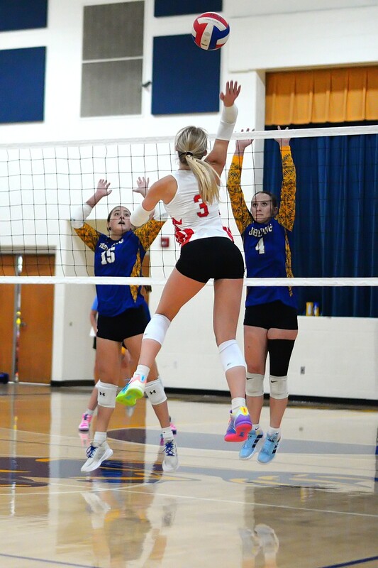 Harper Richardson (3) shoots a kill between two Oblong defenders at the net