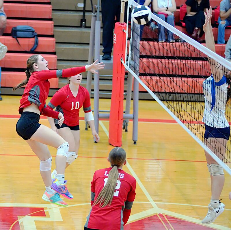 Marshall's Breck Bishop (L) smashes a kill against Martinsville in JV action