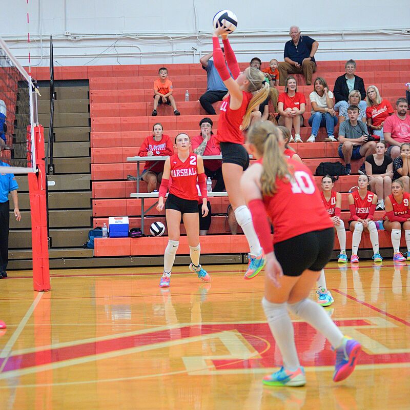Marshall's Harper Richardson (center) bumps the ball over the net against St Anthony
