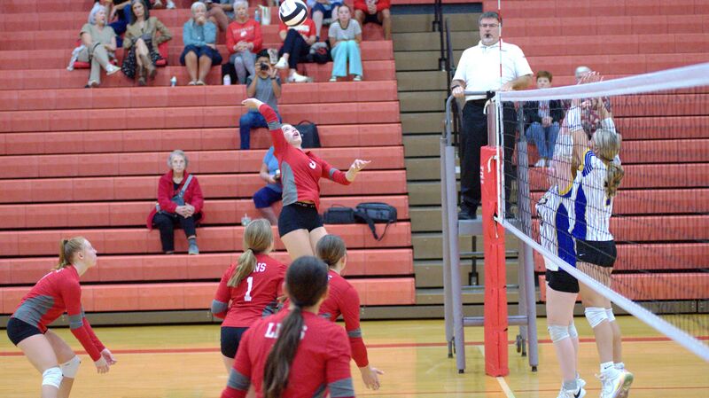 Marshall's Libby Huisinga (3) threads a kill between the blockers from St John's Lutheran
