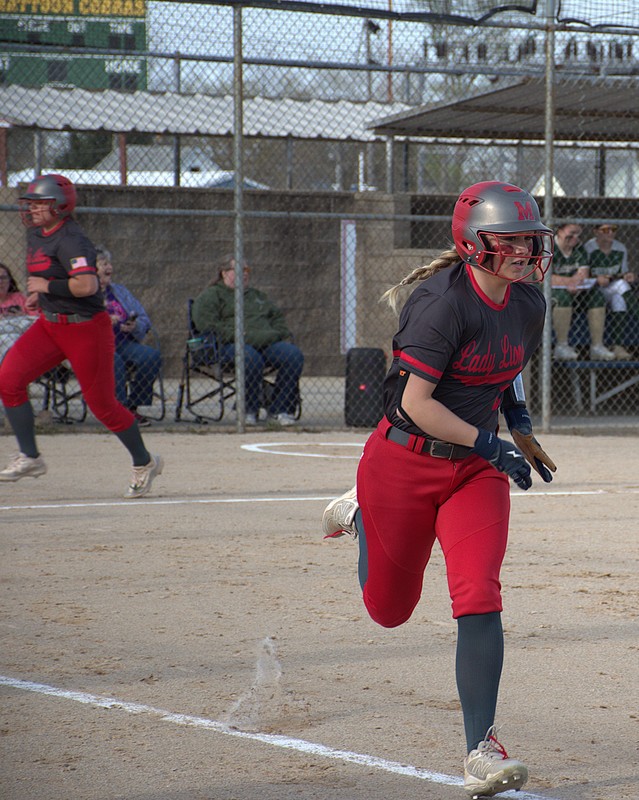 Lilly Nickles (foreground) races to first base after driving the ball through the middle to score Ella Mattas (background) and Kyla Gustafson with Marshall's first 2 runs against Mattoon