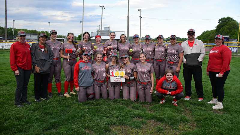 Marshall softball players and coaches mark the 100th career win for head coach Ryan McGuire after beating Casey-Westfield 4-1