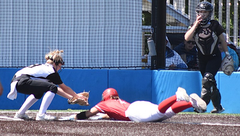 Caitlyn Hilliard slides into home plate head first to beat the tag against Meridian