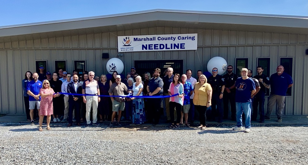 Ribbon cutting outside Needline office