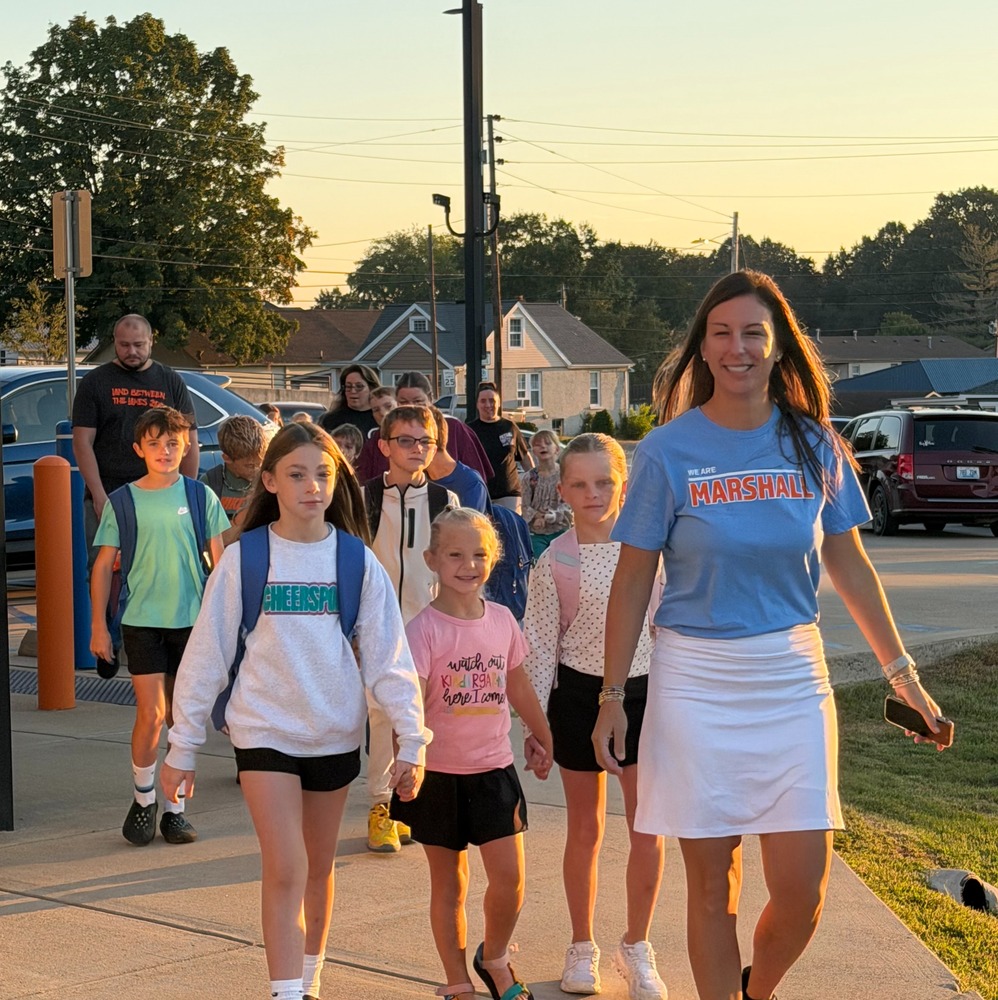 Teacher and student start walking at MC LIbrary headed toward BES on International Walk to School Day