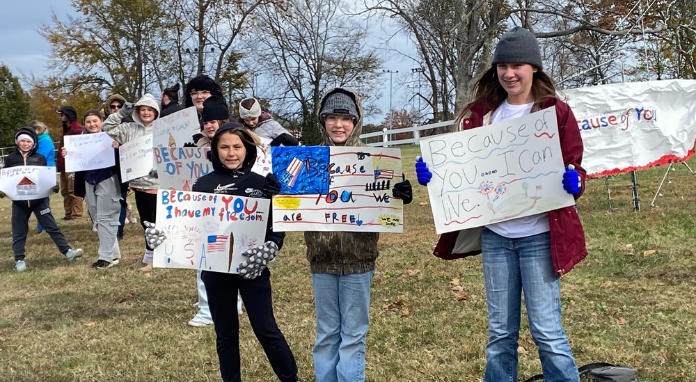 SES Students Line Road with Signs