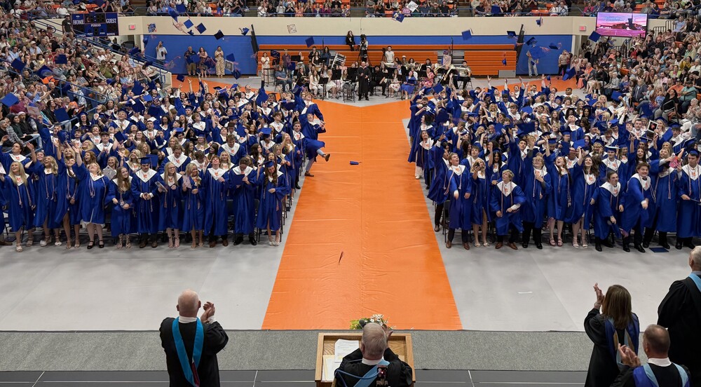 2026 Graduates celebrating by tossing caps in air