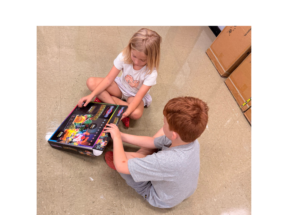 Two students on floor opening box