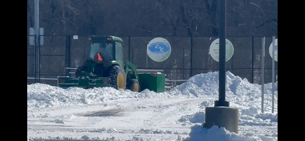 Snow plow clearing MCHS parking lot
