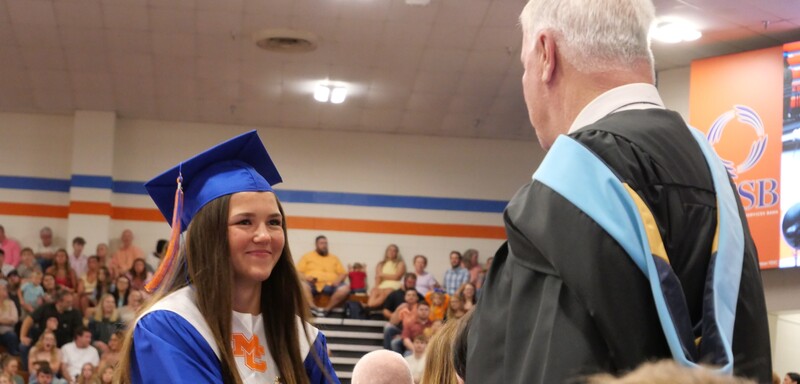Graduate walking across stage to receive diploma