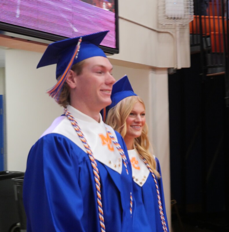 Graduates walking onto gym floor for graduation ceremony