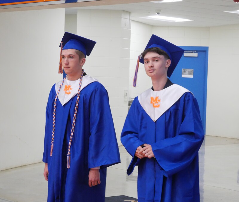 Graduates walking onto gym floor for graduation ceremony