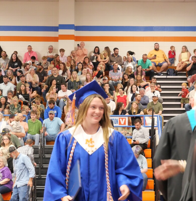 Graduate walking across stage to receive diploma