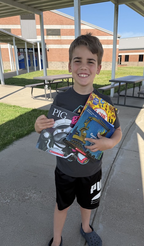 Student with books given away through reading grant