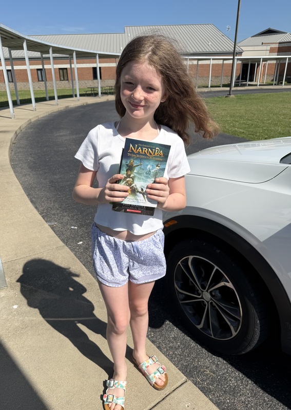 Student with book given away through reading grant