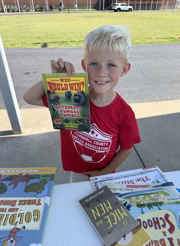 Student with books given away through reading grant