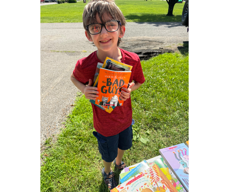 Student with books given away through reading grant