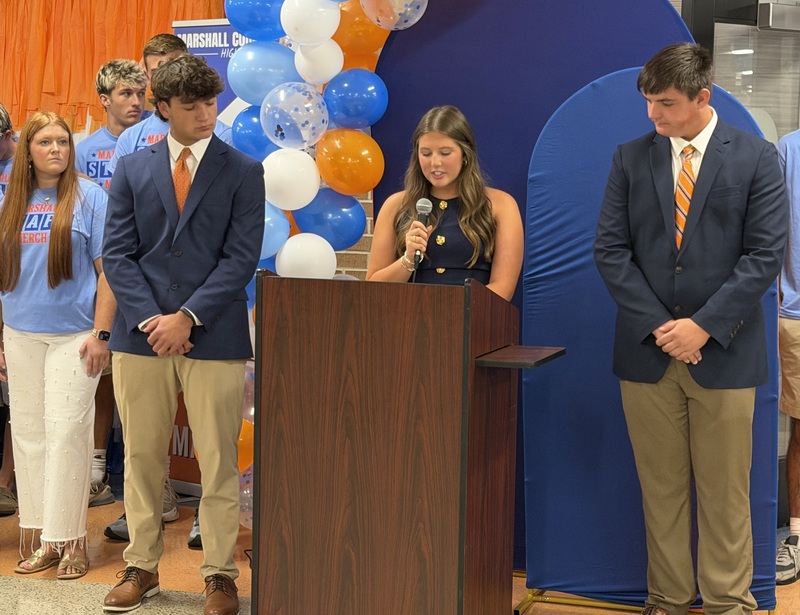 Students speaking at podium during Marshall Merch grand opening