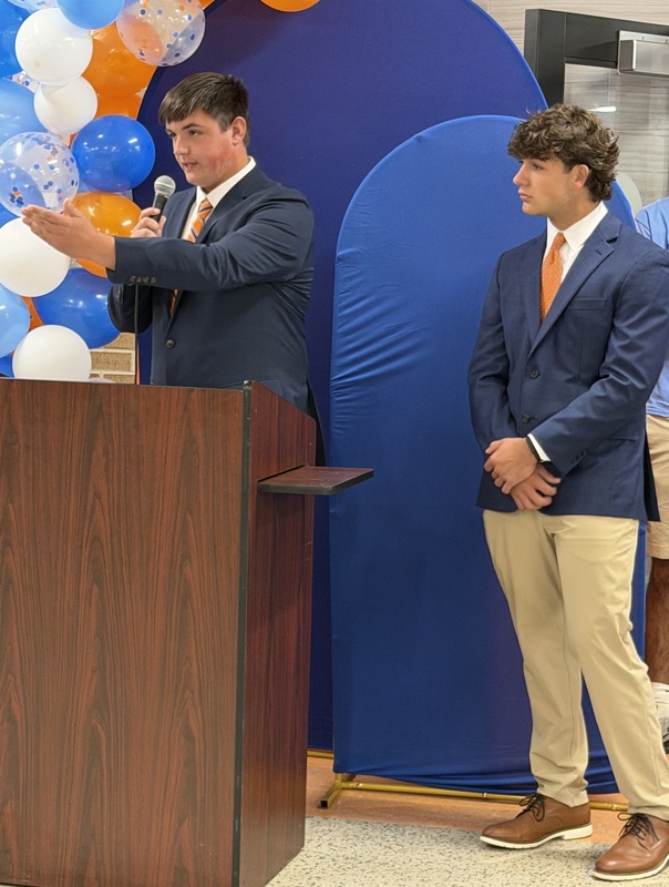 Students speaking at podium during Marshall Merch grand opening