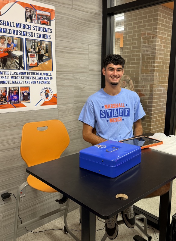 Student behind register at Marshall Merch grand opening