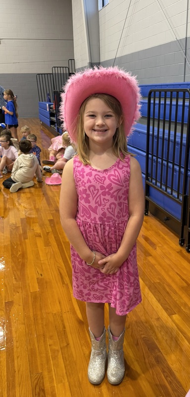 Photo of CCES student in gym dressed in pink cowboy hats in honor of Dolly Parton
