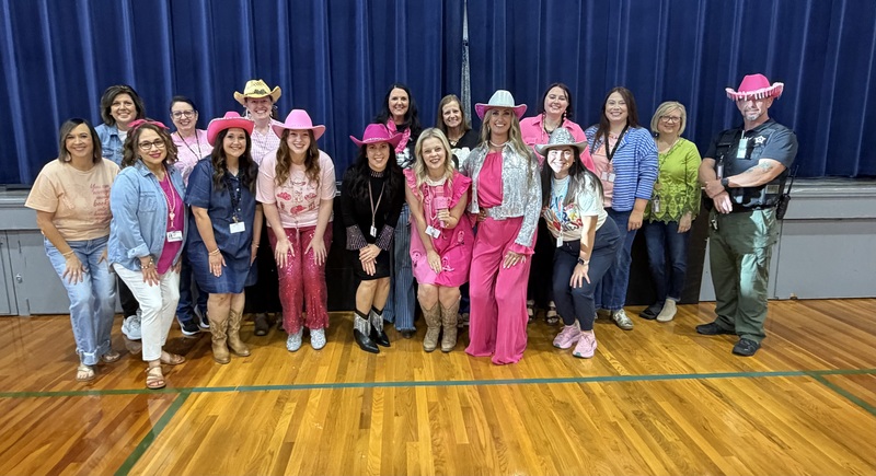 CCES staff Photo of CCES in gym dressed in pink cowboy hats and boots in honor of Dolly Parton