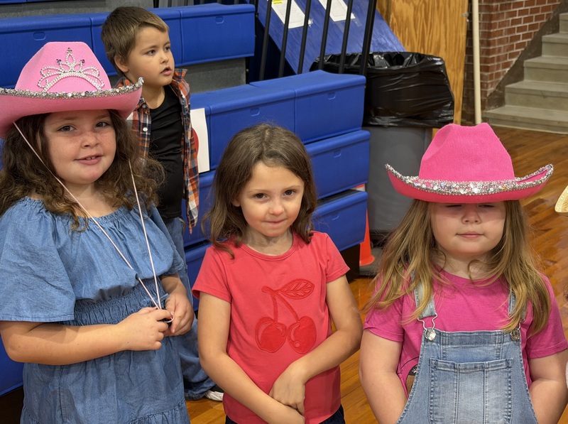 Photo of CCES students in gym dressed in pink cowboy hats in honor of Dolly Parton