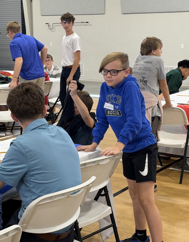 Particpant at Marshall Male Leadership Conference talking to others at table
