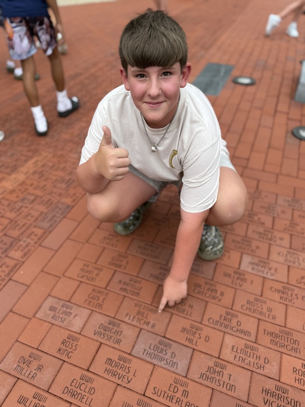 SES student points a memorial brick at Veterans Memorial